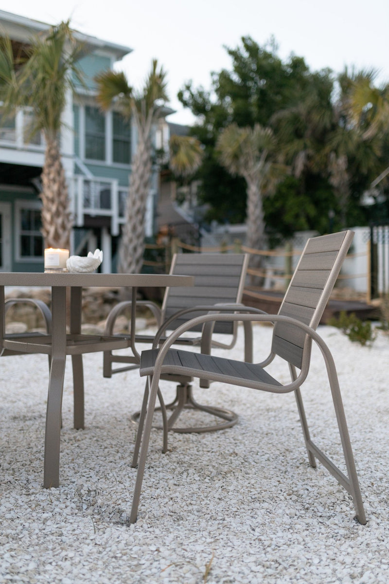 Murphy 42” Round Dining Table in Oak Wood Vein. Murphy Poly Dining Chairs and Murphy Poly Swivel Rocker Dining Chairs in Oak Wood Vein with Coastal Gray poly